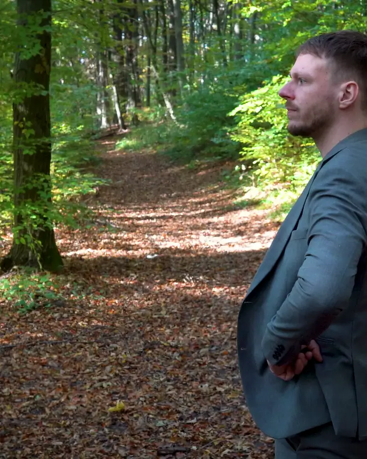 Ausschnitt aus einem Imagefilm der Flamingo Agency: Ein Mann im Sakko geht durch einen herbstlichen Wald